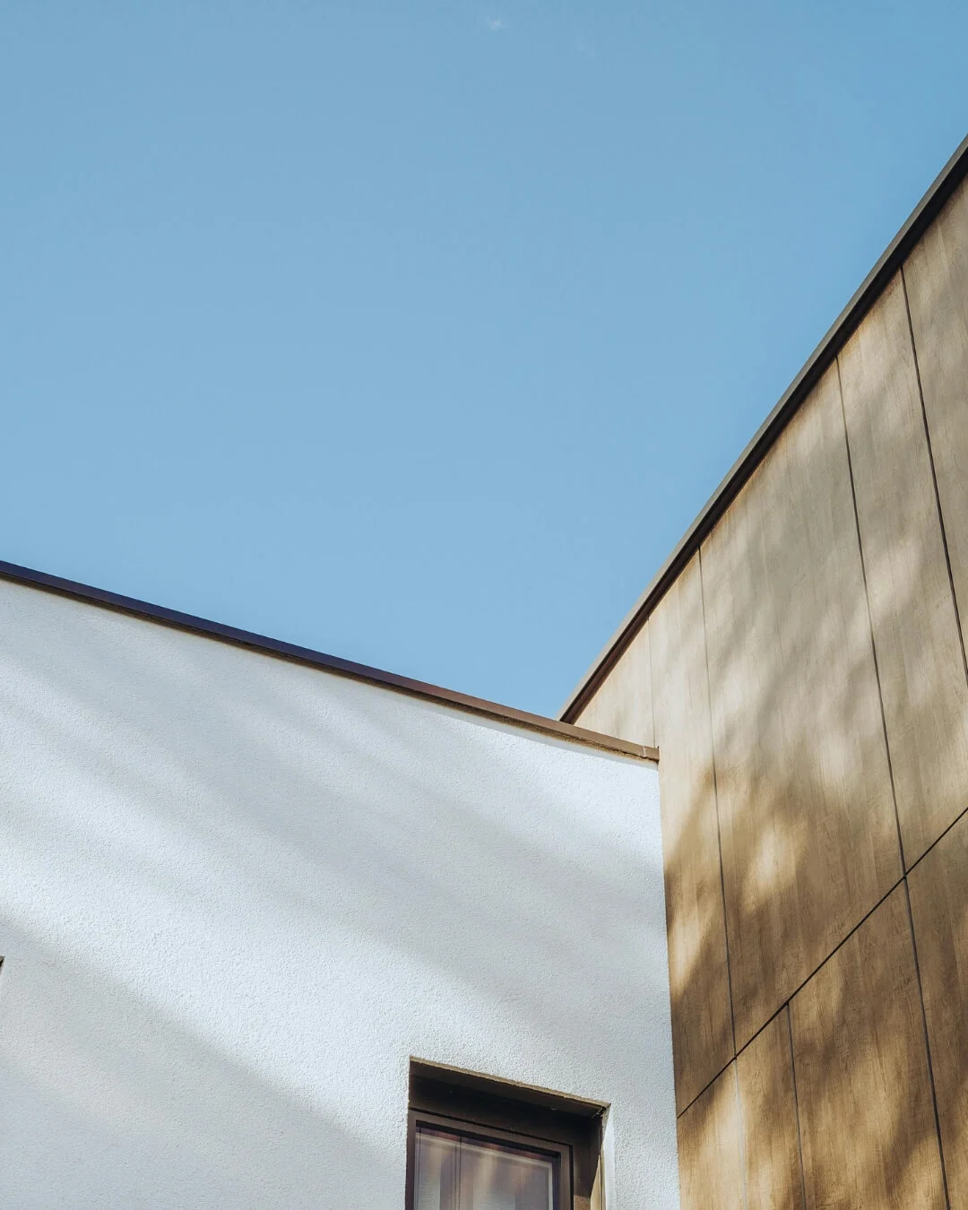 Dettaglio architettonico di facciata Nathea con cielo azzurro